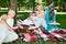 grandparents and grandchildren are resting in the park. horizontal. focus on the chessboard