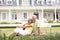 Grandparents And Grandchildren Sitting Outside House On Lawn