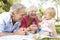 Grandparents And Granddaughter Playing In Park Together