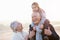 Grandparents And Granddaughter Walking On Winter Beach