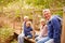 Grandparents with grandkids on bridge in a forest, portrait