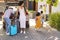 Grandparents Greeting Grandchildren As Parents Unpack Car On Family Holiday