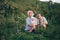 Grandparents holding Granddaughter sitting In Park nature