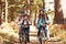 Grandparents and kids cycling on forest trail, California