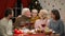Grandparents kissing little girl, big family having Xmas dinner, happy time
