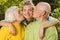 Grandparents kissing their granddaughter