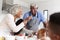 Grandparents In Kitchen With Granddaughter Making Pancakes Together