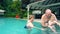 Grandparents playing with child in swimming pool