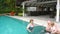 Grandparents playing with granddaughter in pool