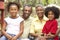 Grandparents Relaxing In Garden With Grandchildren