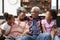 Grandparents Relaxing On Sofa At Home With Granddaughters