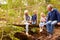 Grandparents sitting with grandkids on a bridge in a forest