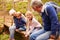 Grandparents sitting with grandkids on wooden bridge