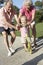 Grandparents Teaching Granddaughter To Ride Scooter In Park