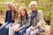 Grandparents and teens sitting on a bridge in a forest