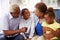 Grandparents and their young grandchildren relaxing at home