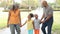 Grandparents Walking With Grandchildren In Park