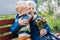 Grandson boy giving a flower to grandma. Grandson and grandmother spending time together. Granny with grandsons enjoying