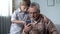 Grandson explaining grandpa how to use smartphone, easy application for elderly