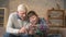 The grandson teaches grandfather to play the console game. An elderly man is learning how to play a video game. Video