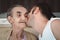 Grandsond kissing his grandma\'s cheek, showing his respect and love