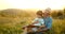 Granfather and grandson laying in grass and reading a book