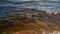 Granite beach with waves and dark water. Northern abstract natural background.