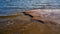 Granite beach with waves and dark water. Northern abstract natural background.