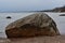 Granite boulder on the border of water and shore.