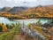 Granite cliff above the river. Stunning winding turquoise river in an autumn mountain valley. Beautiful autumn landscapes with a