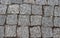 Granite cobblestoned pavement background. Cobbled stone road regular shapes, abstract background of old cobblestone pavement close