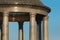 Granite columns of the rotunda support a dome with a transparent roof. Sun glare on the surface of natural stone. It