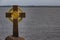 Granite cross stands on the shore of the lake