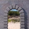 Granite gate with wall and sandy landscape