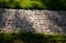 Granite paving of irregular sections of chipped stone around a park with green lawn gray color of the pedestrian path