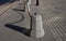 Granite pillars with a stretched black metal chain separate the sidewalk from the roadway