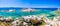 Granite rocks in sea, amazing azure water, white sailboats in background near Porto Pollo, Sardinia, Italy