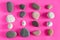 Granite smooth pebbles sea stones on pink background top view