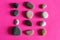 Granite smooth pebbles sea stones on pink background top view