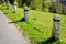 Granite stone bollards old line the mountain road at the moat on the edge of the white curb with a black stripe in a row turn