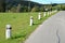 Granite stone bollards old line the mountain road at the moat on the edge of the white curb with a black stripe in a row turn