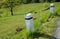 Granite stone bollards old line the mountain road at the moat on the edge of the white curb with a black stripe in a row turn