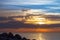 Granite stones on the seashore, a beautiful sky with clouds of sunrise, a sea horizon, tranquility.