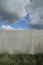 Granite wall with cloudscape and grass underneath