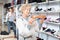 Granny choosing new shoes while standing in salesroom of shoeshop.