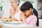 Granny and granddaughter praying at dining table