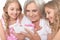 Granny with granddaughters using smartphone