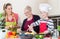 Granny, mum and son talking while cooking in kitchen