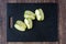 Granny Smith apple quartered on a black cutting board