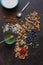 Granola, almonds, raisins, milk, honey and blueberries - the ingredients for a healthy breakfast. Close-up, top view on  dark